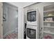 Convenient laundry room with stacked washer and dryer and storage shelves at 12689 Sagewood Dr, Venice, FL 34293