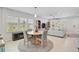 Open-concept dining and living area featuring tiled floors and large windows with plantation shutters at 12689 Sagewood Dr, Venice, FL 34293