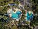 Aerial view of a community pool area featuring a winding pool, lap pool, lounge chairs, and lush tropical landscaping at 12689 Sagewood Dr, Venice, FL 34293