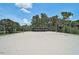 Close-up of a sand volleyball court with mature landscaping at 12689 Sagewood Dr, Venice, FL 34293