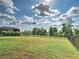 Expansive backyard featuring healthy green grass, black metal fence, and beautiful greenery at 12705 Pinnacle Ln, Venice, FL 34293