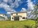 Expansive backyard featuring lush green grass, black metal fence, and a screened in patio at 12705 Pinnacle Ln, Venice, FL 34293