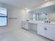 Bright bathroom features double sinks, a makeup vanity, and a walk-in shower at 12705 Pinnacle Ln, Venice, FL 34293
