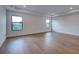 A bright bedroom features wood flooring and natural light from two windows at 12705 Pinnacle Ln, Venice, FL 34293