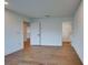 A spacious bedroom featuring hardwood floors, white walls, and doors leading to hallway and closet at 12705 Pinnacle Ln, Venice, FL 34293