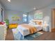 bedroom with bright decor, featuring colorful shelves, art, and a cozy bed and rug at 12705 Pinnacle Ln, Venice, FL 34293
