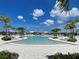 Beautiful community pool surrounded by lounge chairs and palm trees, perfect for relaxation and recreation at 12705 Pinnacle Ln, Venice, FL 34293