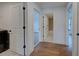 Bright hallway with wood floors, white walls, and doors leading to various rooms including a bathroom at 12705 Pinnacle Ln, Venice, FL 34293