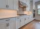 Modern kitchen featuring custom white cabinets, stainless steel appliances, and a decorative tile backsplash at 12705 Pinnacle Ln, Venice, FL 34293