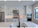 Gourmet kitchen with stainless steel appliances, quartz countertops, custom cabinets and a stylish backsplash at 12705 Pinnacle Ln, Venice, FL 34293
