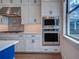 Close up of modern kitchen with stainless steel appliances, custom cabinets, stylish backsplash and eat-in countertop at 12705 Pinnacle Ln, Venice, FL 34293