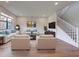 Bright living room showcasing stylish decor, hardwood floors, and a staircase leading to the upper level at 12705 Pinnacle Ln, Venice, FL 34293