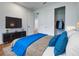 Comfortable bedroom with a TV, a closet, and a bed with a blue blanket and pillows at 12705 Pinnacle Ln, Venice, FL 34293