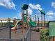 Community playground featuring a safe and fun play structure with slides, climbing areas, and protective ground cover at 12705 Pinnacle Ln, Venice, FL 34293