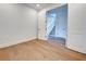 Empty room featuring hardwood floors and minimalist decor with an open doorway with stairs visible in the distance at 12705 Pinnacle Ln, Venice, FL 34293