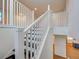 Staircase featuring white railings and black stairs at 12705 Pinnacle Ln, Venice, FL 34293