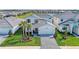 Stunning aerial view of a modern home with manicured landscaping and a brick driveway, situated near a serene lake at 12816 Morning Mist Pl, Venice, FL 34293