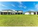 Spacious backyard with lush lawn and view of modern homes at 12816 Morning Mist Pl, Venice, FL 34293