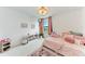 Charming bedroom with pink accents, cozy bedding, and bright natural light from the window at 12816 Morning Mist Pl, Venice, FL 34293