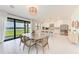 Elegant dining area with a view of the lake, seamlessly integrated with a modern kitchen and ample natural light at 12816 Morning Mist Pl, Venice, FL 34293