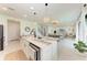 Open-concept kitchen with island flows into the living and dining areas at 12816 Morning Mist Pl, Venice, FL 34293