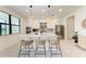 Modern kitchen featuring white cabinets, a large island, stainless steel appliances, and bar stool seating at 12816 Morning Mist Pl, Venice, FL 34293