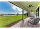 Screened patio with chairs overlooking green lawn and water view at 12816 Morning Mist Pl, Venice, FL 34293