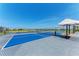 Bright blue community pickleball court, fenced in with lake view for active recreation and leisurely games at 12816 Morning Mist Pl, Venice, FL 34293
