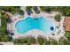 Aerial shot of the community pool featuring a unique shape and plenty of lounge seating at 13486 Nobilio St, Venice, FL 34293