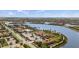 An aerial view of community clubhouse with pool and surrounding homes by the lake at 13486 Nobilio St, Venice, FL 34293