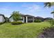 Well-manicured backyard with lush green grass, tasteful landscaping, and a screened-in lanai at 13486 Nobilio St, Venice, FL 34293