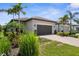 Inviting single-story home with a well-maintained lawn, lush landscaping, and a two-car garage at 13486 Nobilio St, Venice, FL 34293