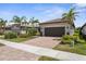 Charming single-story home featuring a manicured lawn, paver driveway, and beautiful landscaping at 13486 Nobilio St, Venice, FL 34293