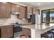 Stylish kitchen with stainless steel appliances, breakfast bar, tile floors, and ample cabinet space at 13486 Nobilio St, Venice, FL 34293
