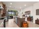 Bright kitchen with stainless appliances, an island, and sliding doors opening to a patio at 13486 Nobilio St, Venice, FL 34293