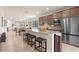 Open-concept kitchen featuring an island with seating and stainless steel appliances at 13486 Nobilio St, Venice, FL 34293
