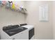 Modern laundry room featuring front-load washer and dryer, with a storage shelf above at 13486 Nobilio St, Venice, FL 34293
