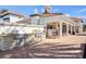 Outdoor kitchen featuring stone accents, stainless steel appliances, and a brick patio at 13486 Nobilio St, Venice, FL 34293