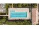 An aerial view shows the large rectangular swimming pool, lounge chairs and manicured grounds at 13486 Nobilio St, Venice, FL 34293