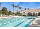 Beautiful swimming pool with palm trees, lounge chairs, and a pool-side cabana at 13486 Nobilio St, Venice, FL 34293