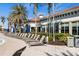 Lounge chairs lined up beside the pool with palm trees and green landscaping at 13486 Nobilio St, Venice, FL 34293