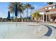 Shallow pool with a water feature and nearby sun loungers, complemented by palm trees at 13486 Nobilio St, Venice, FL 34293
