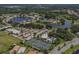 Panoramic aerial view of community amenities including tennis courts, pool, and surrounding green spaces at 1531 Belfry Dr, Venice, FL 34292