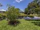Backyard featuring a canal with lush green landscaping and glimpses of neighboring homes at 1531 Belfry Dr, Venice, FL 34292