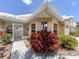 A sunny entrance featuring an arched doorway, a white security gate, and lush greenery at 1531 Belfry Dr, Venice, FL 34292