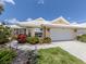 Inviting home exterior showcasing a white roof, manicured lawn, and colorful landscaping at 1531 Belfry Dr, Venice, FL 34292