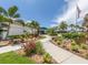 The Waterford Sports Club entrance featuring lush landscaping, a walkway and a flagpole at 1531 Belfry Dr, Venice, FL 34292