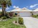 Charming single-story home with a well-manicured lawn, lush landscaping, and white tiled roof at 1531 Belfry Dr, Venice, FL 34292