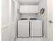 Clean laundry room featuring modern appliances, overhead cabinets, and neutral tones at 1531 Belfry Dr, Venice, FL 34292