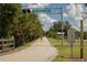 Legacy Trail bike path lined with trees under a partially cloudy sky at 1531 Belfry Dr, Venice, FL 34292